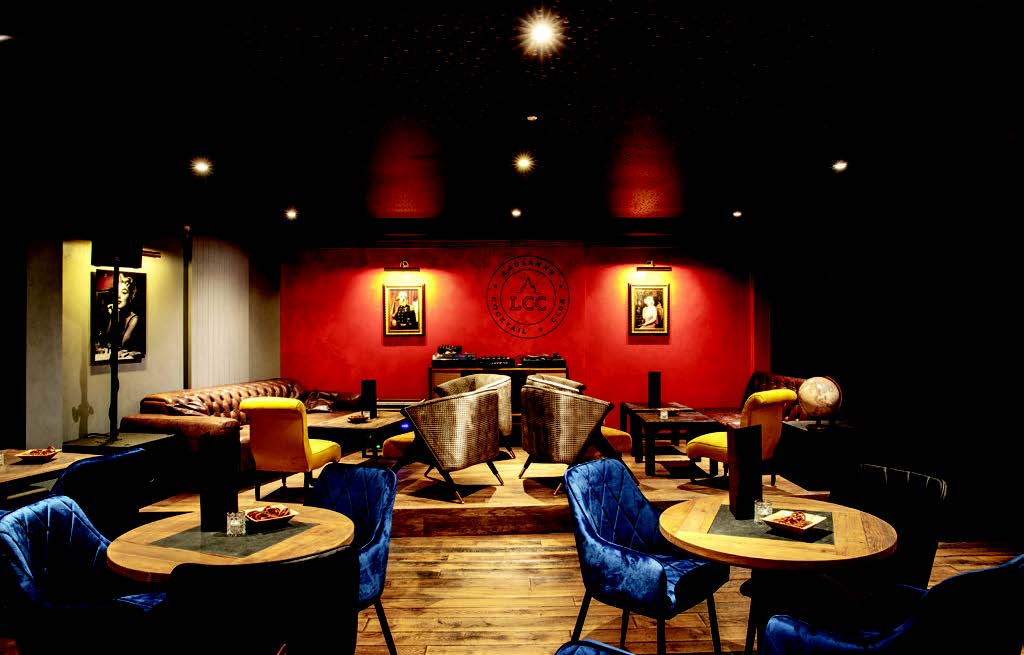 It's a picture of the Lausanne cocktail club. We see blue chairs and a red wall.